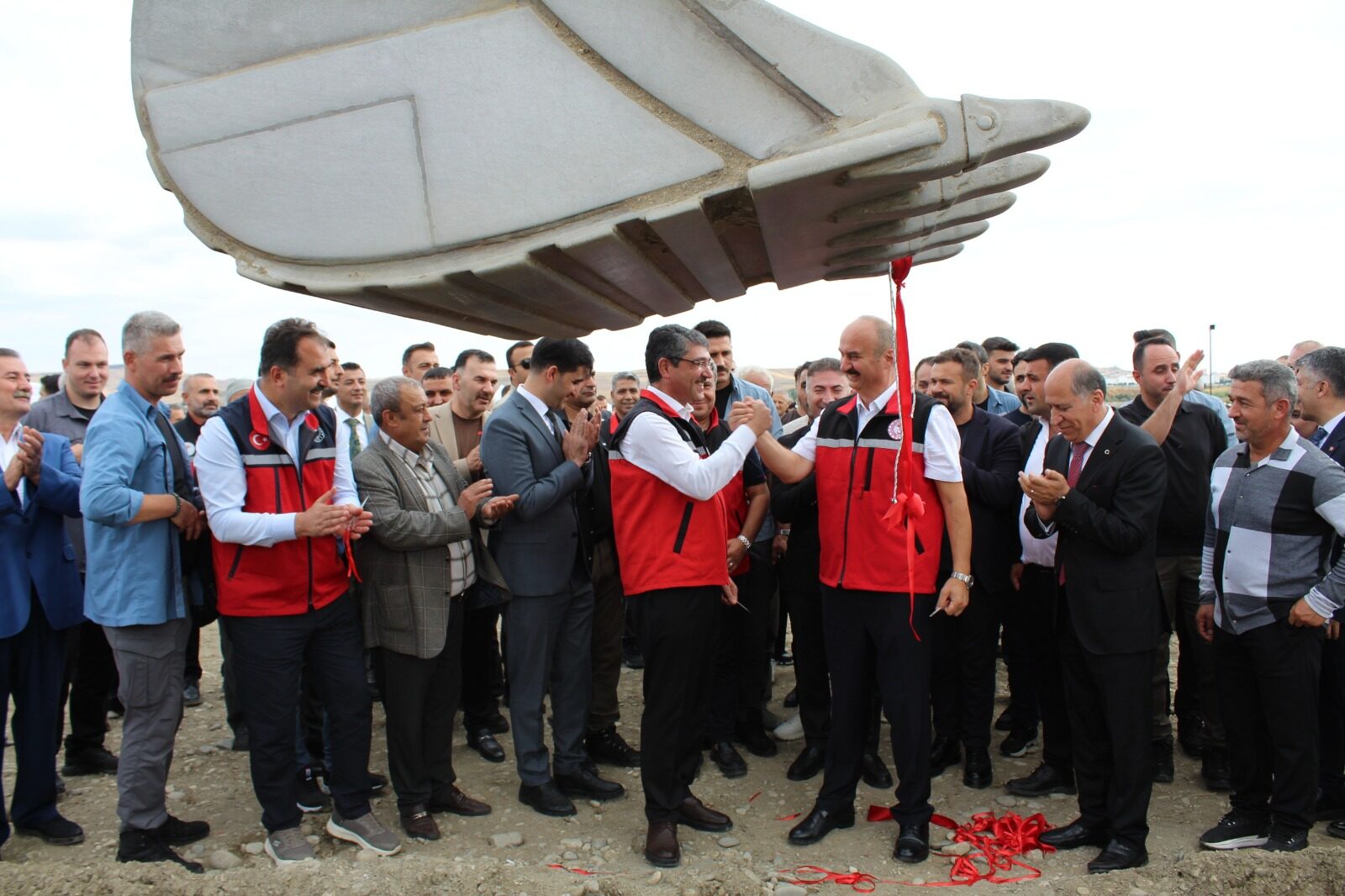 Participants beside an excavator bucket at the Batman Sera OTB launch ceremony