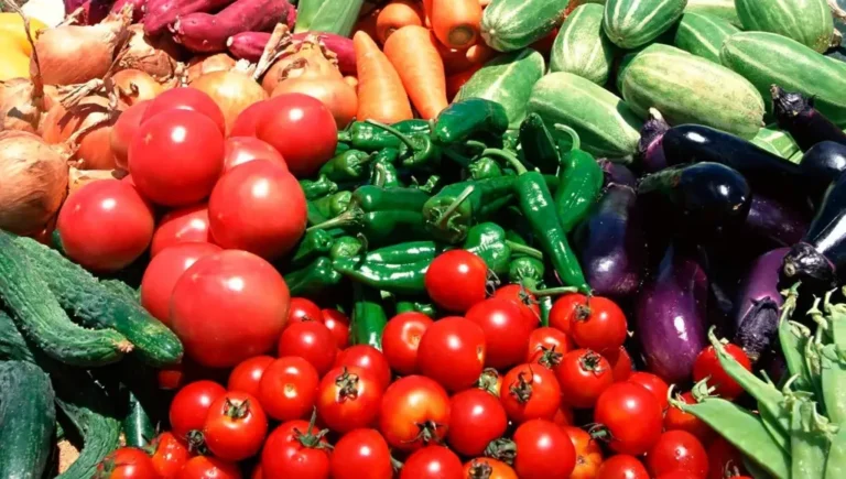 Market display of tomatoes, peppers and aubergines